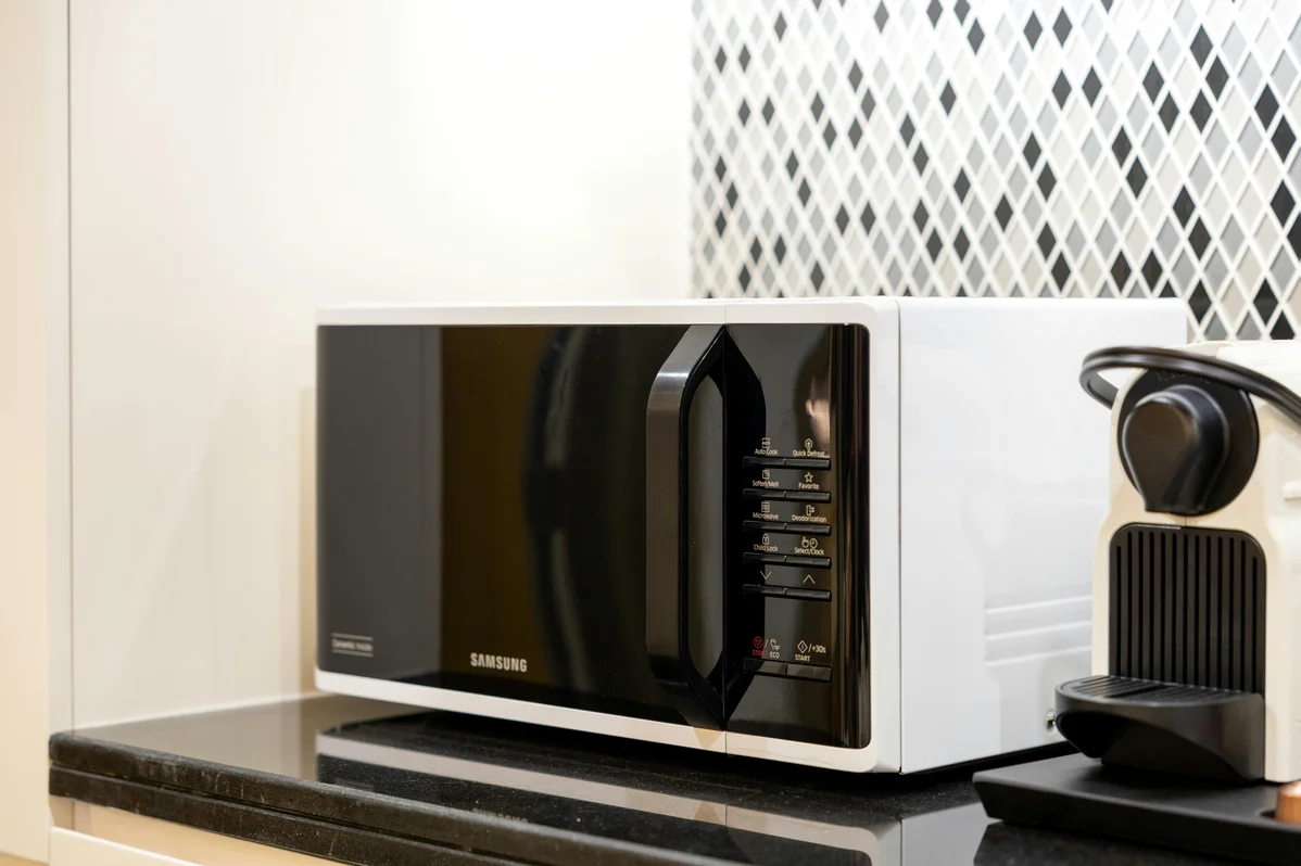 A vintage woodgrain microwave and toaster displayed together, representing classic household items from the 1980s A vintage woodgrain microwave and toaster displayed together, representing classic household items from the 1980s