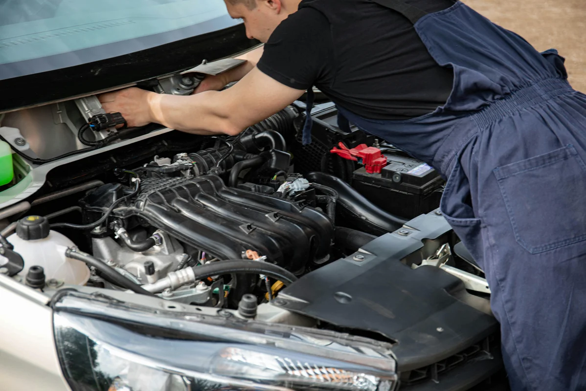 A mechanic inspecting a car's suspension system for damage A mechanic inspecting a car's suspension system for damage