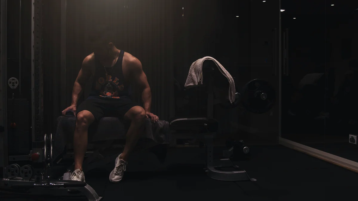 A person performing strength training while another engages in cardio A person performing strength training while another engages in cardio