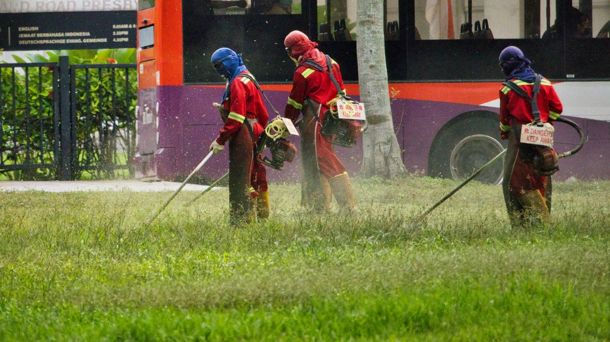 A person applying pre-emergent weed control to a lawn in early spring A person applying pre-emergent weed control to a lawn in early spring